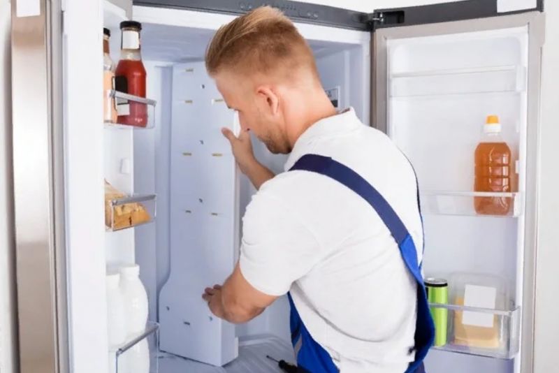 Специалист ремонтирует холодильник Мир
